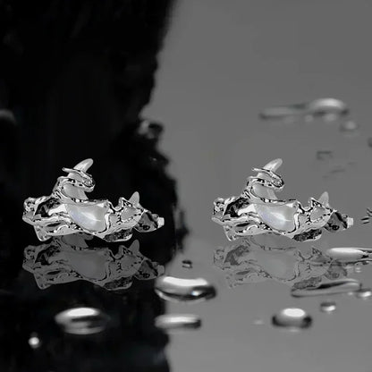 Silver rings on a reflective surface with water droplets.