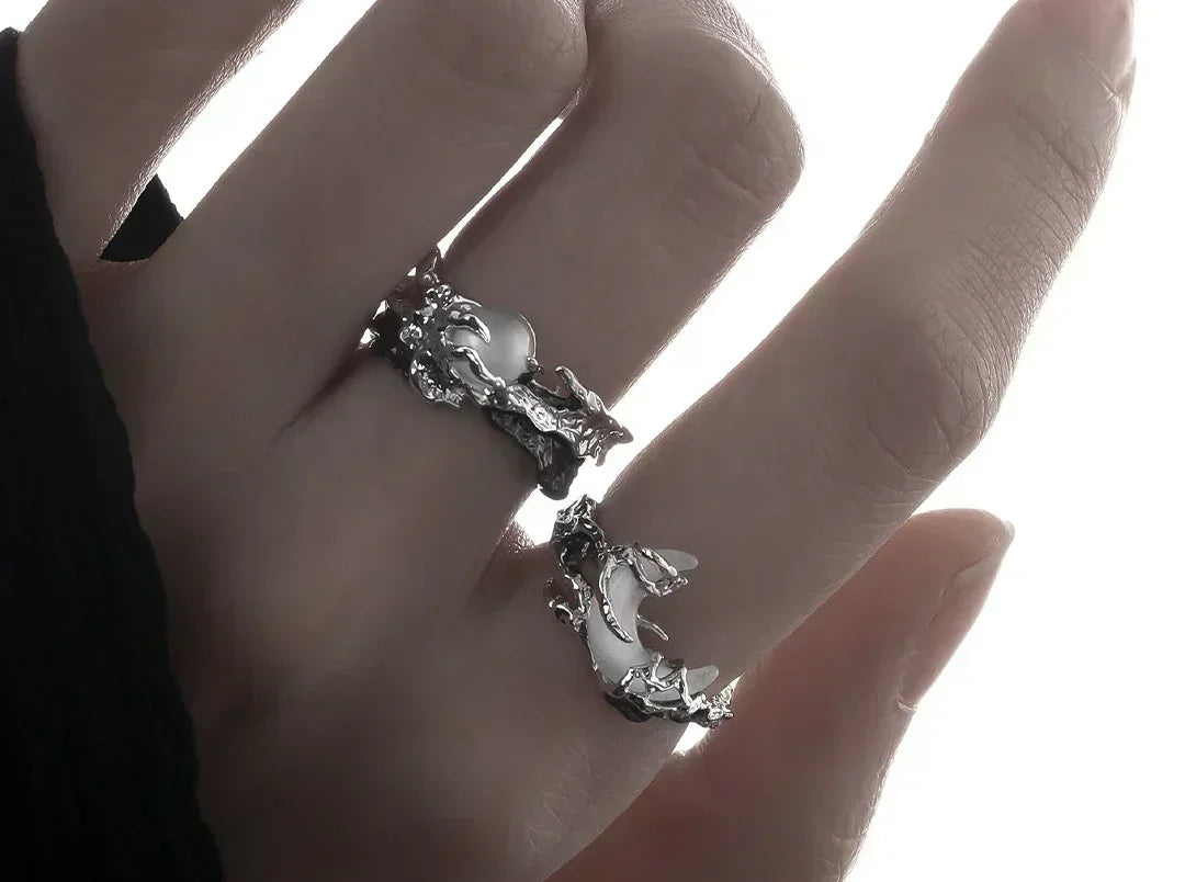 Silver ring with Moon and Sun design on a hand.